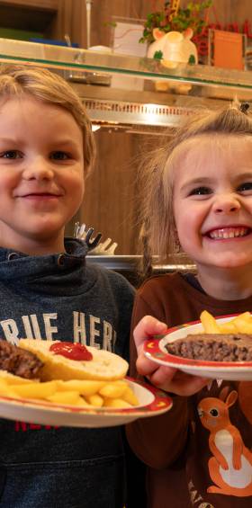 Zwei Kinder präsentieren ihre Burger am Buffet, kinderfreundliche Verpflegung im Familotel