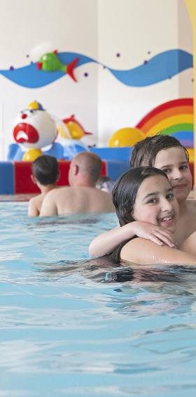 Familie hat Spaß im Poolbereich des Schwimmbads