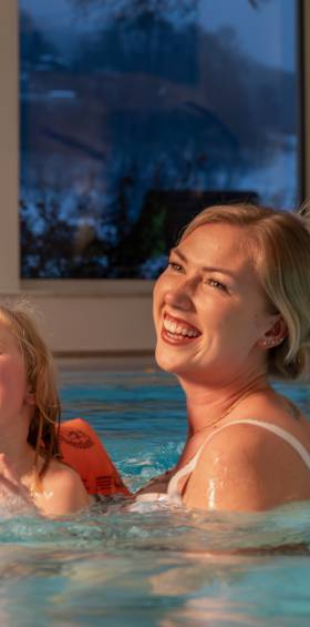 Mutter und Kind genießen das Schwimmen zusammen im Familotel Schwimmbad