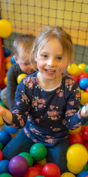 Mädchen im Bällebad im Indoor-Spielbereich