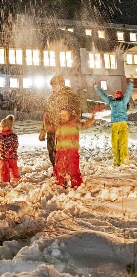 Familie machen eine Schneeballschlacht im Winter vor dem Familotel Mein Krug