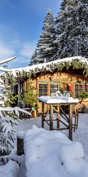 Winterliche Szene mit einer dekorierten Hütte und verschneiter Landschaft im Naturpark Fichtelgebirge