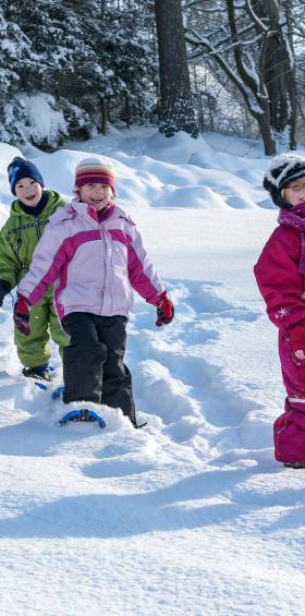 Familie mit Kindern erkundet die winterliche Landschaft des Naturparks Fichtelgebirge auf Schneeschuhen