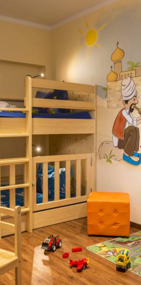 Spielerisches Kinderzimmer im 4-Raum-Apartment mit Malerei an den Wänden und Spielzeug.