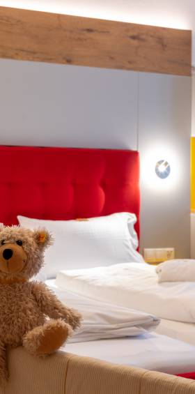 Familienzimmer mit Baldachinbett und kuscheligem Teddy