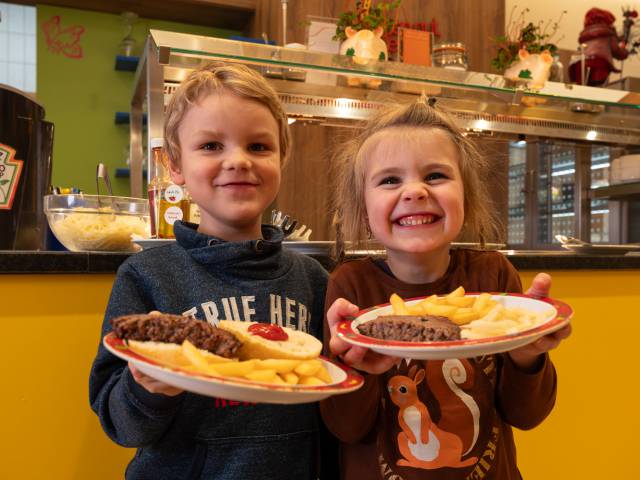 Zwei Kinder präsentieren ihre Burger am Buffet, kinderfreundliche Verpflegung im Familotel