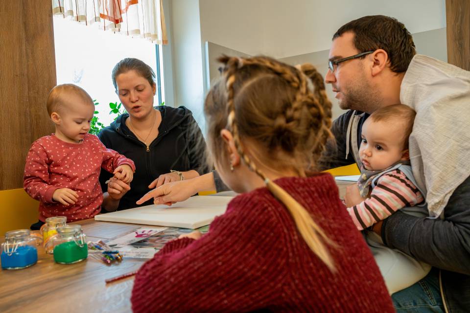 Familie mit kleinen Kindern beim gemeinsamen Basteln im Familienhotel