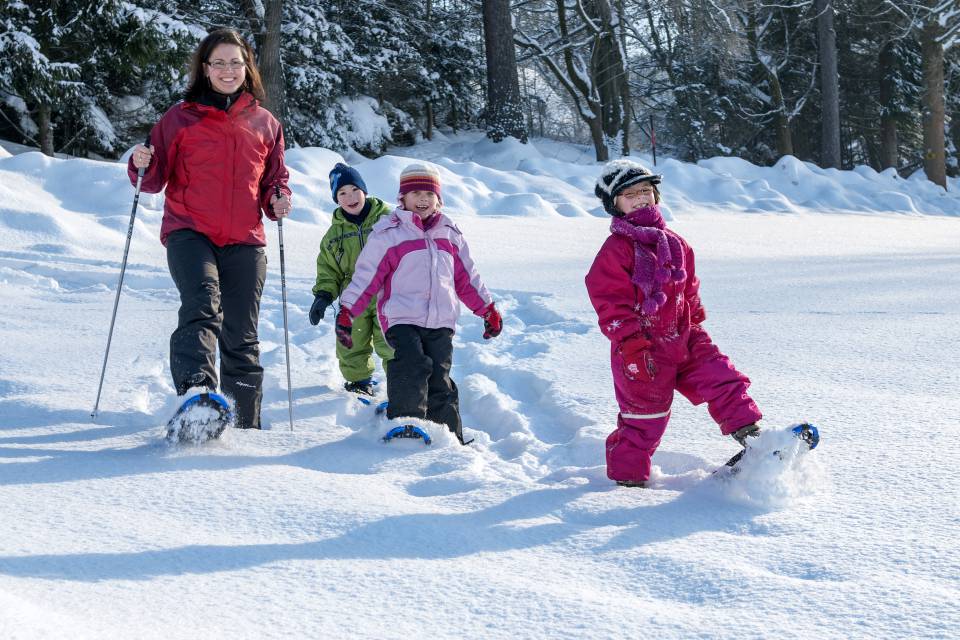 Familie mit Kindern erkundet die winterliche Landschaft des Naturparks Fichtelgebirge auf Schneeschuhen