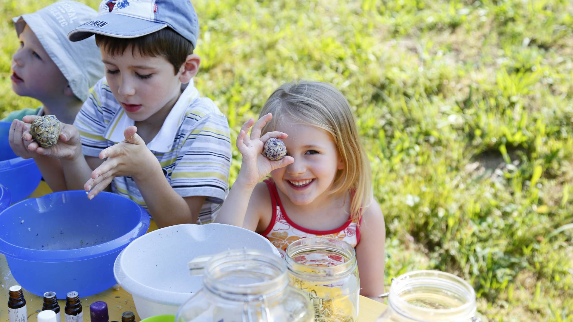 Kinder basteln mit Naturmaterialien und Kräutern im Freien